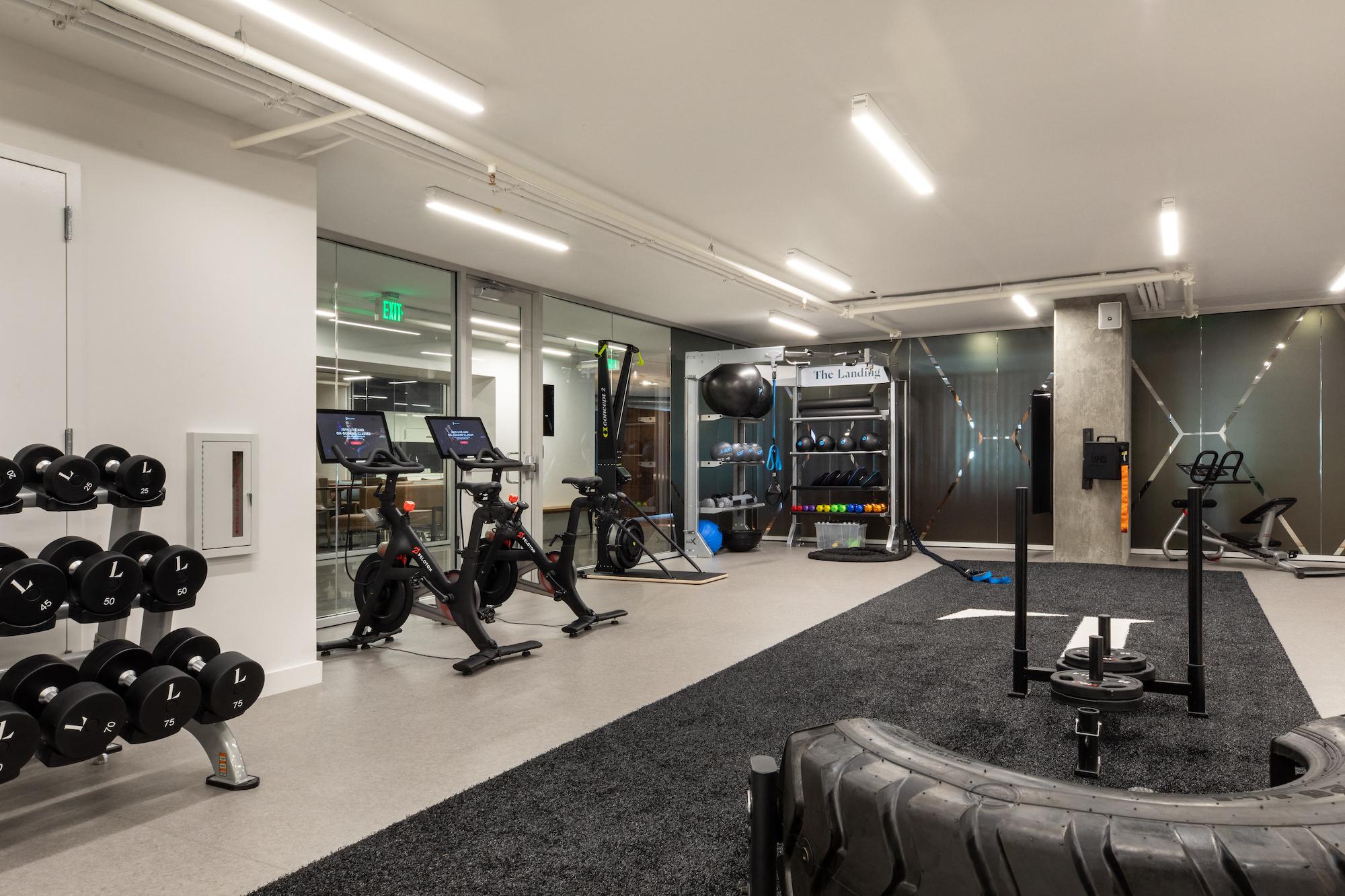a gym with exercise equipment and mirrors on the wall