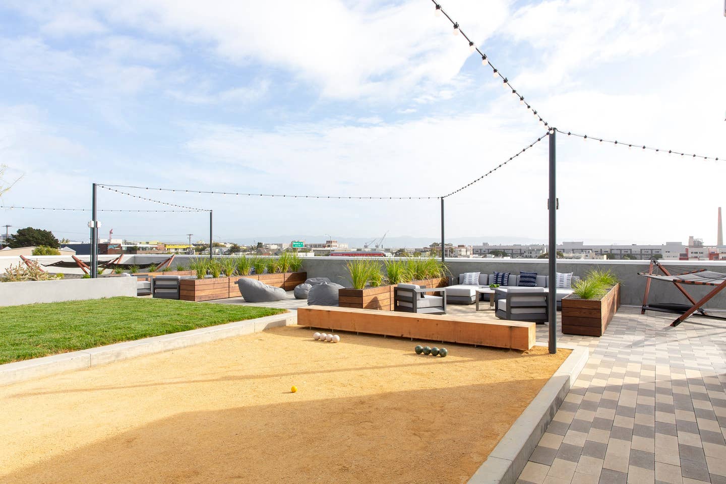 a roof terrace with furniture and grass