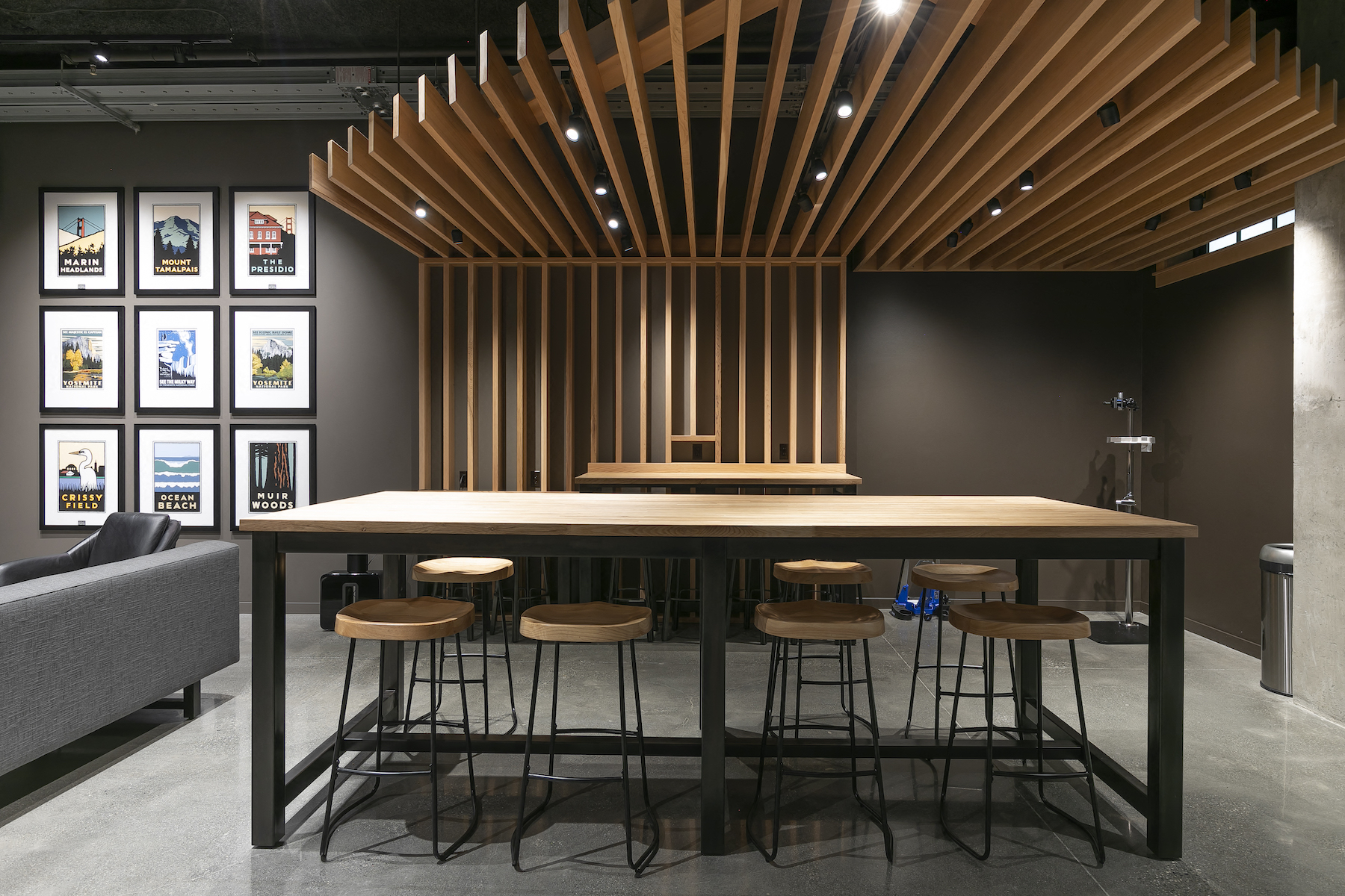 a long communal table with chairs in a room with pictures on the wall