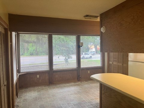 A room with a large window and a tiled floor.