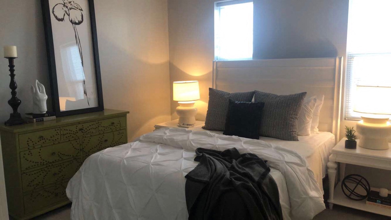 a bedroom with a bed and a mirror and a dresser