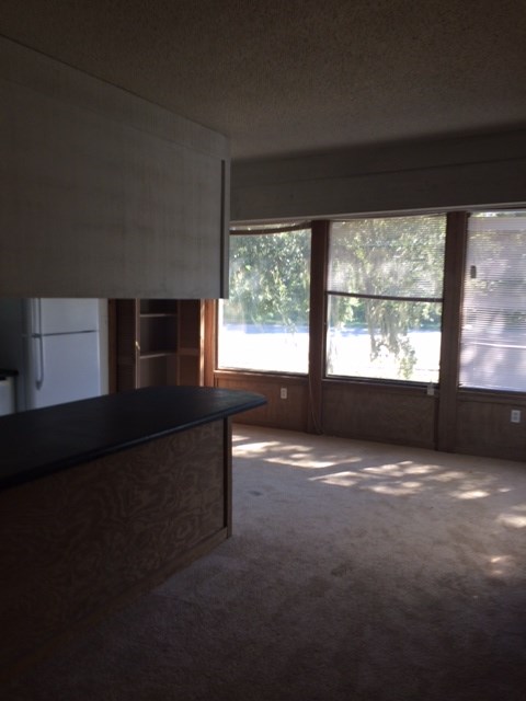 A room with a black counter and a window overlooking a parking lot.