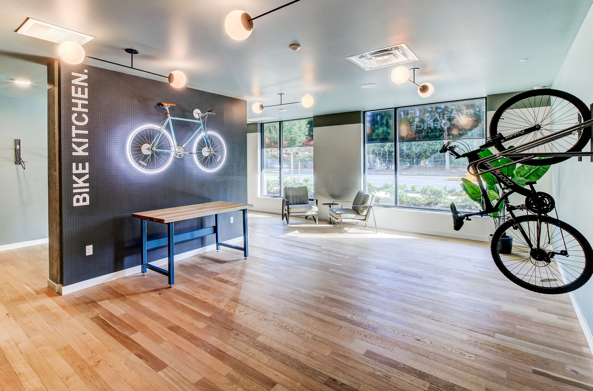 a bike hanging from the ceiling in a room with a desk