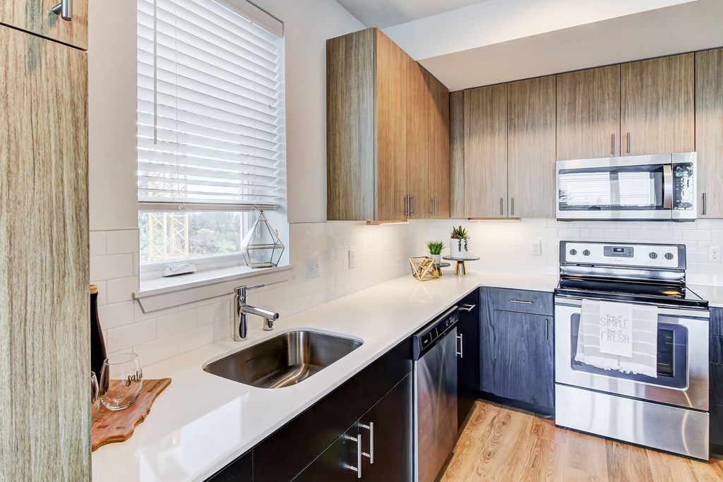 a kitchen with white counter tops and wooden cabinets