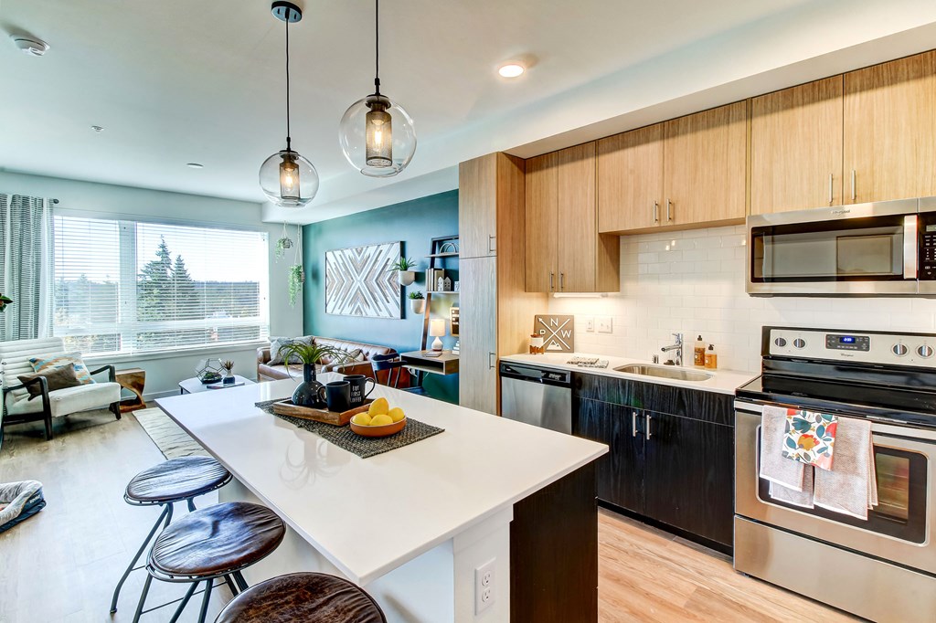 an open kitchen with a large island with a white counter top