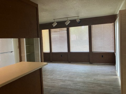 A room with a wooden floor and brown walls.