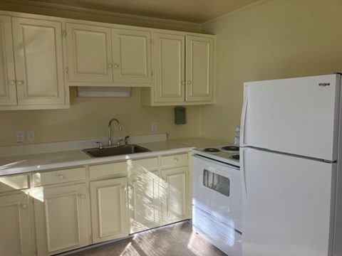 a kitchen with white appliances and white cabinets