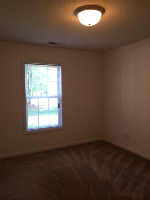 A room with a window and a ceiling light.