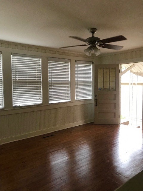 a living room with a ceiling fan and a door