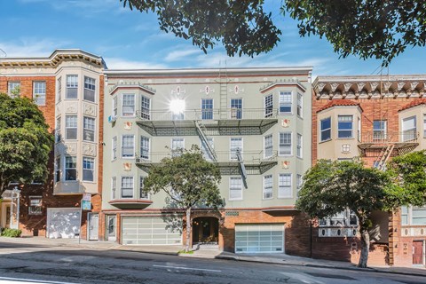 A street view of a row of apartment buildings.