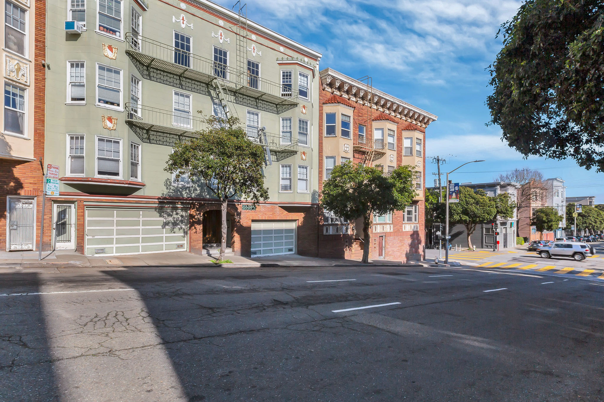 A street view of a residential area with buildings and a clear sky.