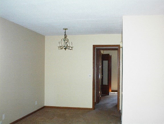 A room with a chandelier and a door.