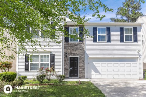 a white house with blue shutters and a garage door