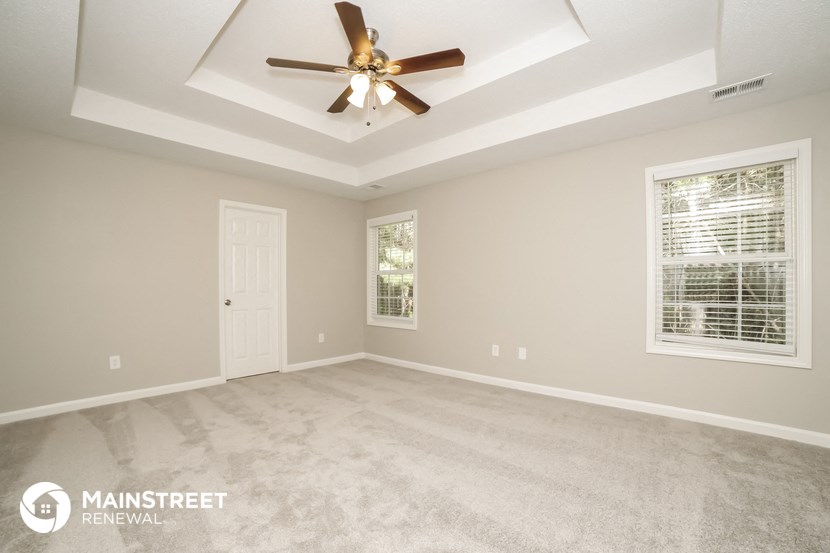 the master bedroom has a vaulted ceiling and a ceiling fan