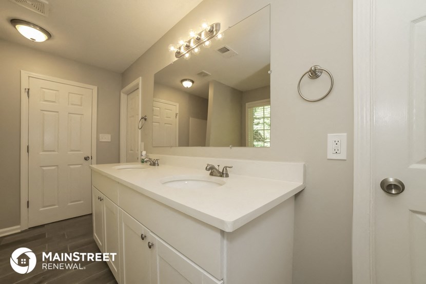 a bathroom with a white sink and a large mirror