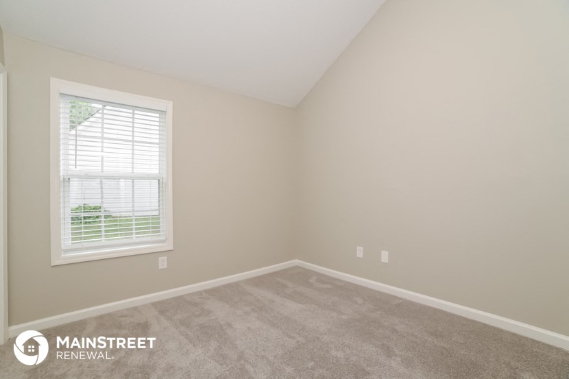 the upstairs bedroom with carpet and window