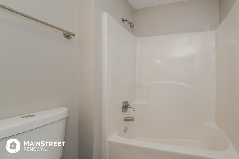 a white bathroom with a shower and a toilet