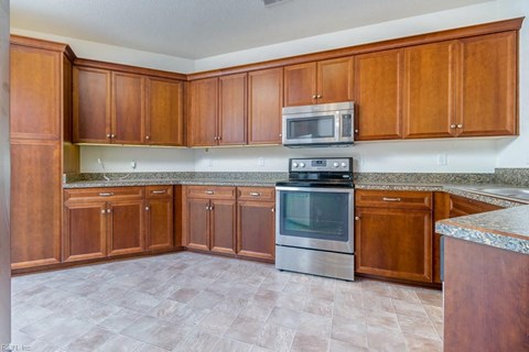 a kitchen with wooden cabinets and stainless steel appliances