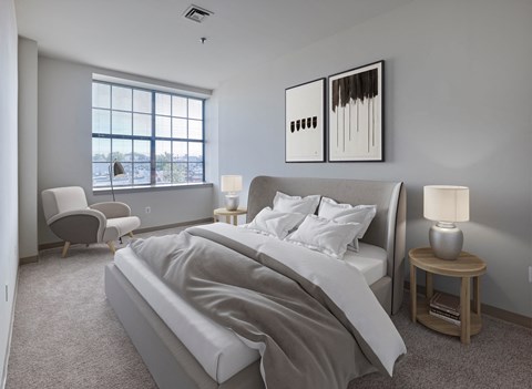 A bedroom with a large bed and a window overlooking the water.