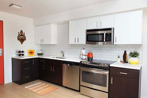 A kitchen with a red door and white cabinets.