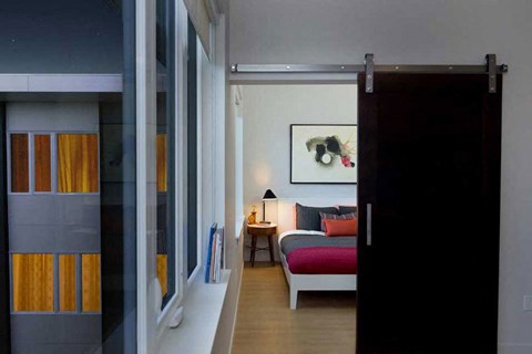 A room with a bed and a painting on the wall.