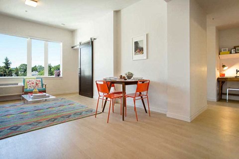 A dining room with a table and chairs.