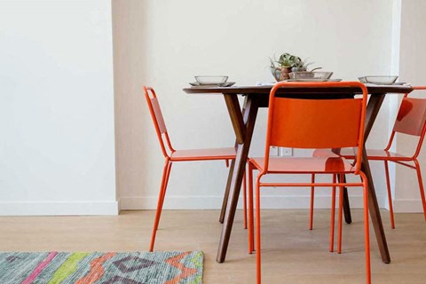 A table with four chairs and a potted plant on it.