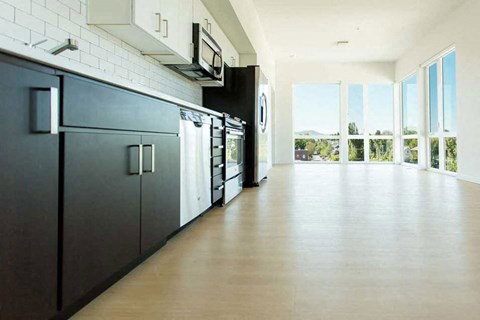 A kitchen with dark wood cabinets and a white brick wall.
