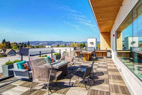 A patio with a table and chairs overlooking a cityscape.