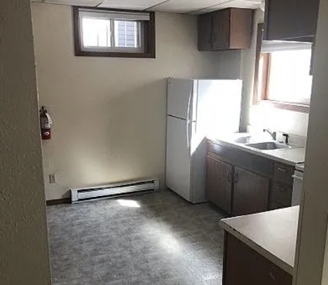 A kitchen with a white refrigerator and a window.