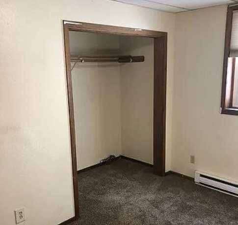 A room with a white wall and a doorway leading to another room.