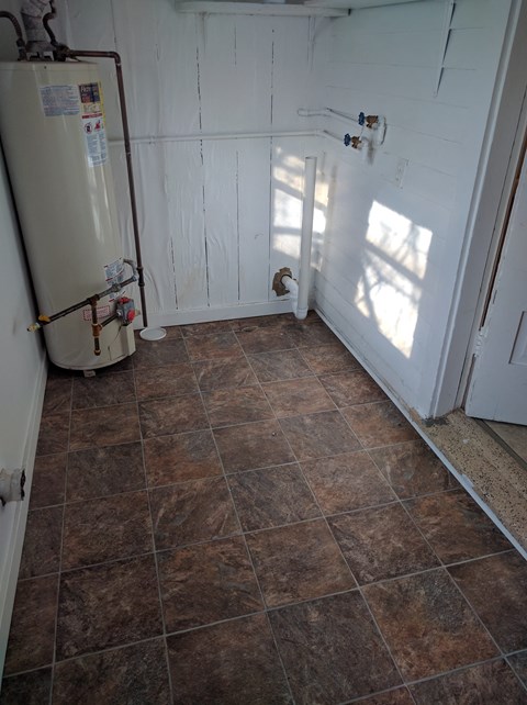 a bathroom with a refrigerator and a tiled floor