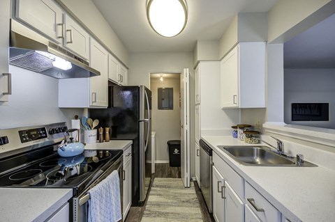a kitchen with white cabinets and stainless steel appliances