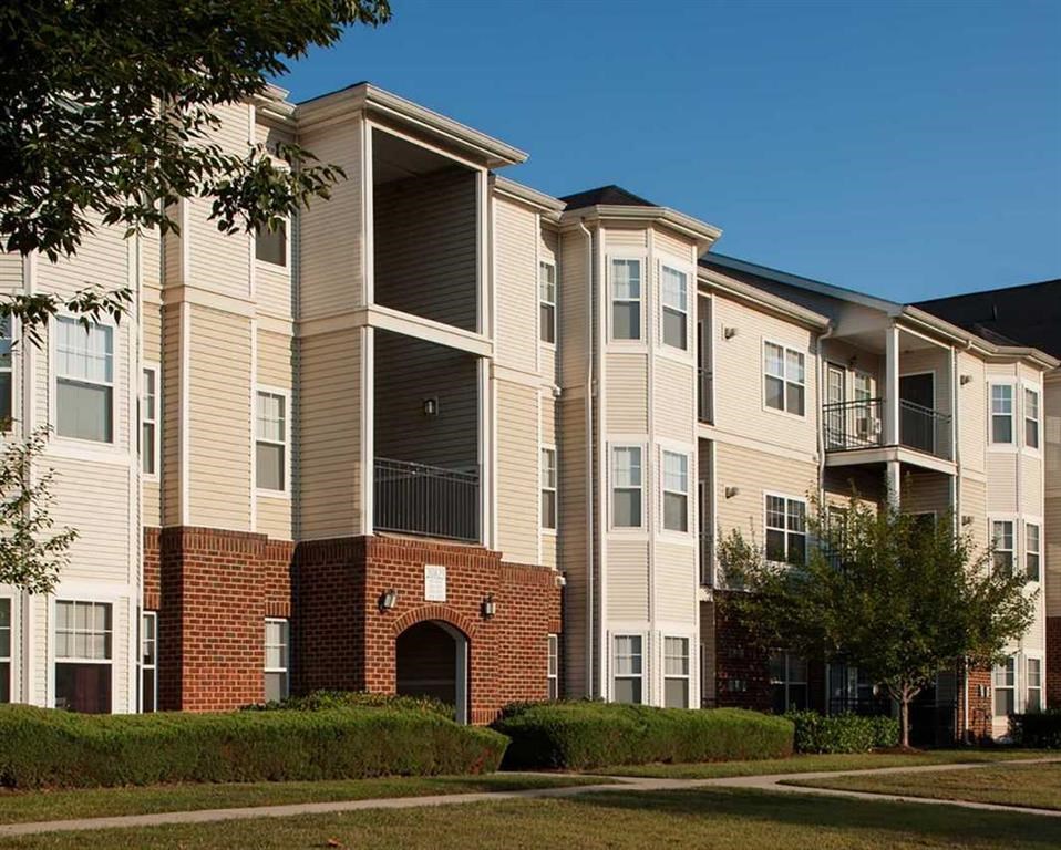 an apartment building with brick and tan siding