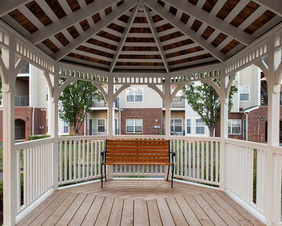 a gazebo with a bench on a porch
