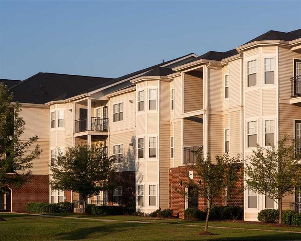 an apartment building with trees in front of it