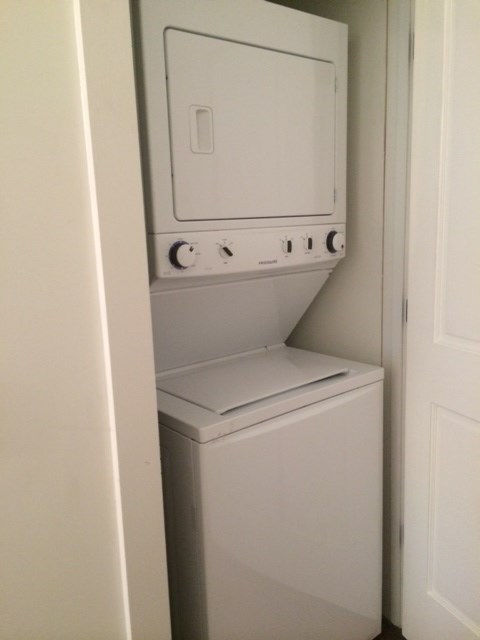 a white washer and dryer in a white closet