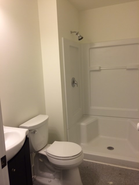 A white toilet sits next to a sink in a small bathroom.