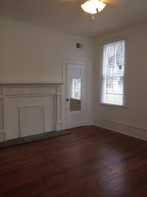 an empty living room with wood floors and a white door