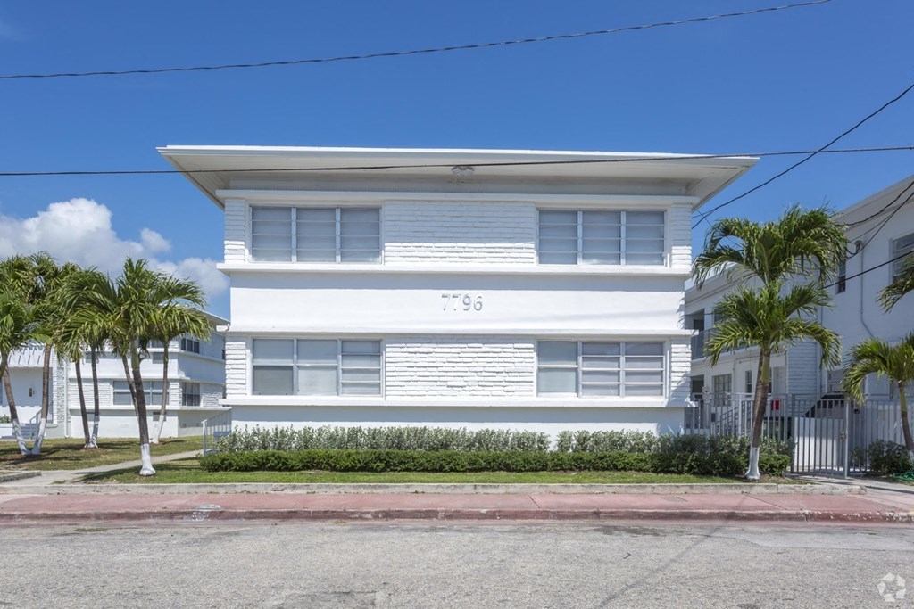 a white house with palm trees in front of it
