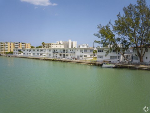 a row of apartments overlooking a river with buildings in the background