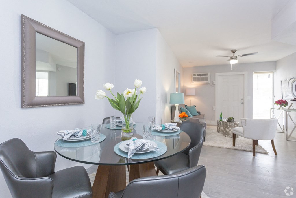 a dining room with a table and chairs and a mirror