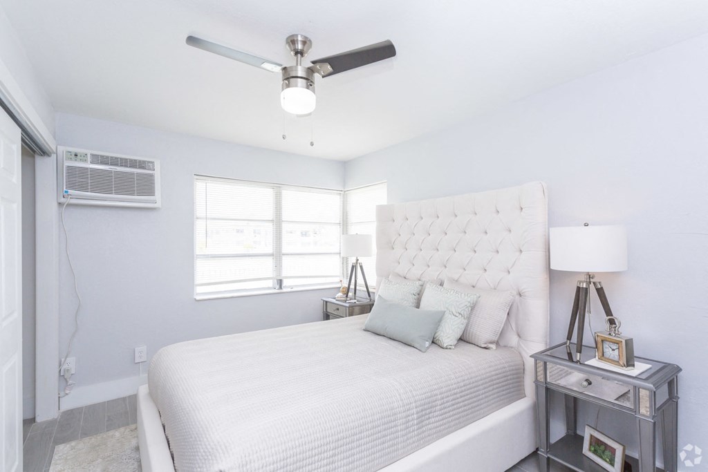 a bedroom with a large bed and a ceiling fan