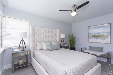 a bedroom with a large bed and a ceiling fan
