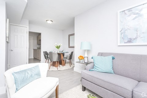 a living room with a couch and a chair and a dining room table