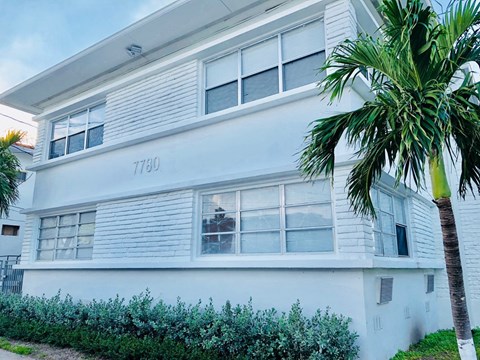 a white house with a palm tree in front of it