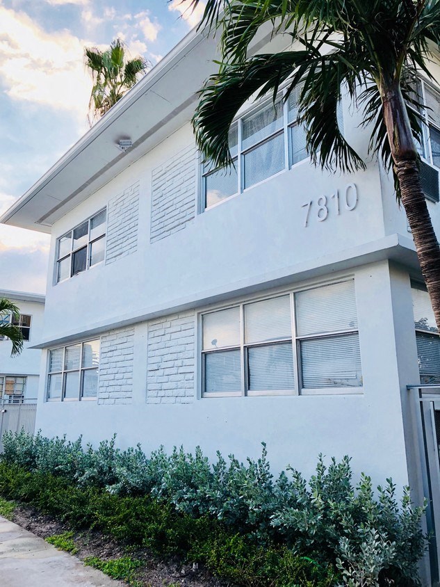 a white building with a palm tree in front of it