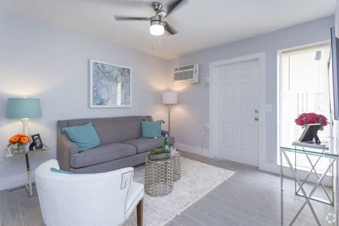 a living room with a couch and a ceiling fan