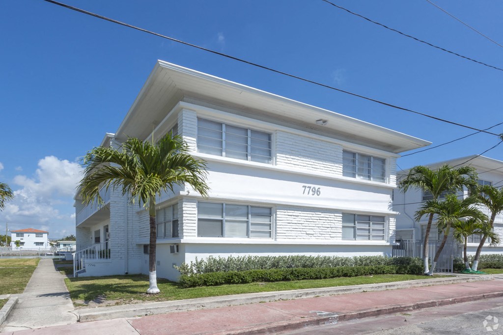 a white house with palm trees in front of it
