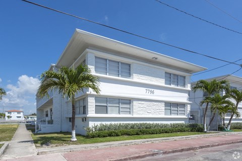 a white house with palm trees in front of it